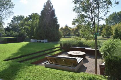 El espacio se hundió unos 60cm y se le creó un entorno con contenedores de chapa. Para acceder, en dos de sus lados se hicieron amplios peldaños de alzada de chapa y pedada de césped