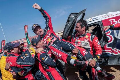 El español Carlos Sainz, celebra junto al francés Stephane Peterhansel y Nasser Al-Attiyah de Qatar, al coronarse campeón del Dakar 2020