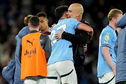 El español Pep Guardiola, técnico del Manchester City, festeja con Matheus Nunes tras la victoria sobre el Aston Villa, el martes 22 de abril de 2025 (Martin Rickett/PA via AP)