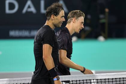 El español Rafael Nadal camina con el canadiense Denis Shapovalov durante el partido de play-off por el tercer puesto del Campeonato Mundial de Tenis Mubadala en el emirato del Golfo de Abu Dabi.