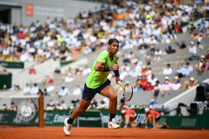 El español Rafael Nadal corre por el balón para devolvérselo al argentino Diego Schwartzman durante el partido de tenis de cuartos de final de individuales masculinos el día 11 del torneo de tenis Roland Garros 2021 del Abierto de Francia en París el 9 de junio de 2021 (Foto de Christophe ARCHAMBAULT / AFP )