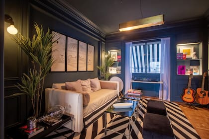 El estar es el sector más rockero de la casa. Enmarcado sobre una alfombra espigada de El Espartano, hay un sillón y una serie de cuadros de Fonchi Martínez del Campo. La mesa de mármol, diseñada por Chule, tiene libros de música y los cómics favoritos de sus hijos. Al fondo, un parlante de Bang & Olufsen y algunas de sus guitarras.