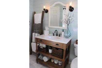 El estilo campestre aparece aquí a través del mueble de madera lustrada con mesada de mármol