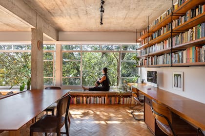 El estudio diseñó el escritorio y las bibliotecas usando madera enchapada, que luego tiñeron para llevarla al tono del parquet.