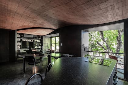 El estudio mantiene la continuidad de un cielorraso curvo de ladrillo que cubre todo el ambiente y se deja ver desde la calle