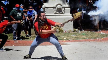 El ex candidato a diputado nacional santafesino Sebastián Romero, disparando un arma casera contras las fuerzas de Seguridad, en los alrededores del Congreso