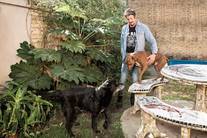 El ex Jugate Conmigo juega con sus mascotas, Rocco −el pitbull− y Rumba −el labrador− en el patio de su casa.
