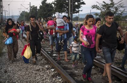 El éxodo a toda costa: decenas de refugiados que escapan de las guerras de Medio Oriente caminan sobre las vías en Idomeni, Grecia, en su intento de llegar a Macedonia