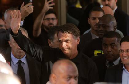 El expresidente brasileño Jair Bolsonaro saluda a sus simpatizantes afuera de la sede del Partido Liberal, en Brasilia, el jueves 30 de marzo de 2023. (AP Foto/Gustavo Moreno)
