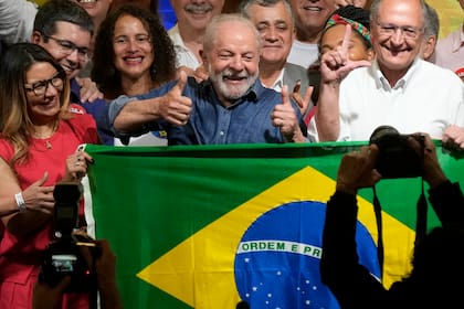 El expresidente brasileño Luiz Inácio Lula da Silva celebra con su esposa Rosangela Silva, izquierda, y su compañero de fórmula Geraldo Alckmin, derecha, después de que la autoridad electoral dijera que derrotó al titular Jair Bolsonaro para convertirse en el próximo presidente del país, en Sao Paulo, Brasil, el domingo 30 de octubre de 2022.
