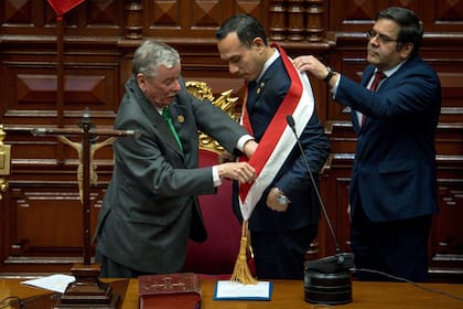 El expresidente del Congreso de Perú, José Jerí, recibe la banda presidencial de manos del congresista Fernando Rospigliosi (izquierda), durante su juramentación como presidente interino en Lima, Perú