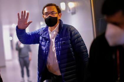 El expresidente peruano Martín Vizcarra saluda a la prensa a su llegada a casa luego de salir del Palacio Presidencial en Lima, luego de su juicio político