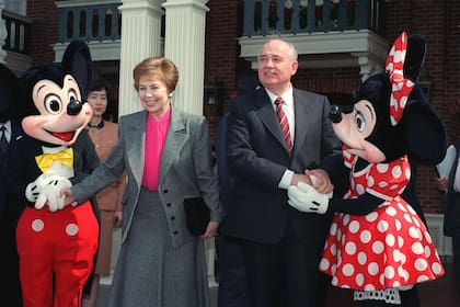 El expresidente soviético Mijail Gorbachov y su esposa Raisa se dan la mano con Mickey y Minnie Mouse en la entrada de Tokyo Disneyland, el 12 de abril de 1992