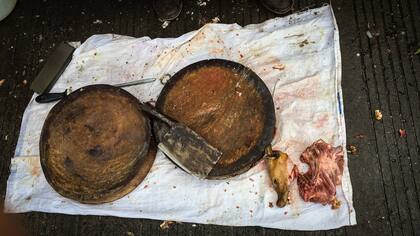 Un proveedor parado al lado de las tablas que utiliza para cortar la carne de perro en el mercado de Nanqiao en Yulin, en la región meridional de Guangxi, China