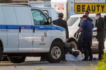 El forense del condado de Los Ángeles saca un cadáver de una furgoneta en Torrance, California, el domingo 22 de enero de 2023.