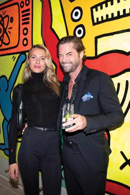 El fotógrafo Lucas Flores Pirán y su mujer Anna Boschiero posan delante de un grafiti del artista Keith Haring