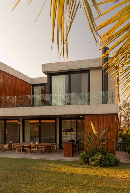 El frente exterior es de hormigoón visto con revestimiento varillado de lapacho, un contrapunto de materiales al que se suman las barandas de vidrio y los grandes ventanales.