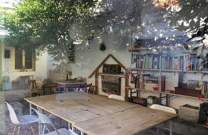 El frente vidriado de la sala multiuso reflejando la calma del atardecer.