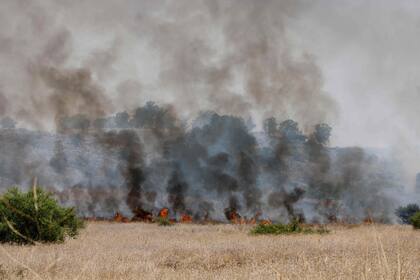 El fuego y el humo se elevan después de que cohetes lanzados desde el sur del Líbano golpearon áreas en el norte de Israel el 4 de julio de 2024.