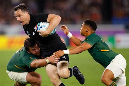 Ben Smith intenta atropellar contra la zancadilla de Frans Malherbe; Nueva Zelanda vs. Sudáfrica implica destrezas vs. poderío físico.
