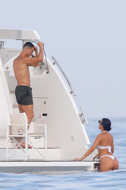 El futbolista, con un estado físico impresionante, se ducha para sacarse la sal, mientras Georgina lo mira. Ella, de bikini blanco, se bañó en el mar con un impactante collar de diamantes.
