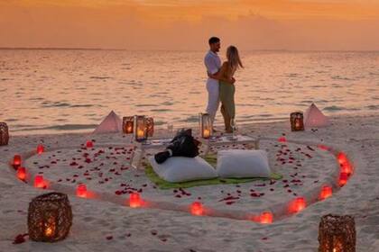 El futbolista y su novia se mostraron felices a orillas del mar y cerca de una corazón armado en la arena con velas rojas