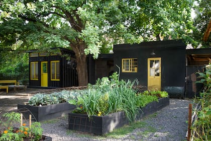 El galpón y el taller de cerámica. En la huerta se observan repollos, puerros, lechugas y copetes.