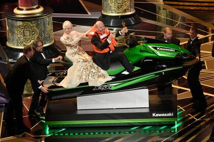 El ganador del Oscar a mejor diseño de vestuario por El hilo fantasma, montado al jet ski junto a Helen Mirren