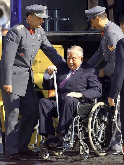 El general Augusto Pinochet es escoltado por oficiales del Ejército a su llegada a una base de la Fuerza Aérea en el aeropuerto de Pudahuel, en Santiago de Chile, el viernes 3 de marzo de 2000.(AP Photo/Ricardo Mazalan)