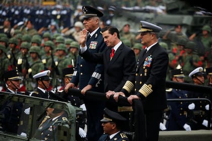 El general Cienfuegos, a la izquierda, fue miembro del gabinete del presidente Peña Nieto, al centro