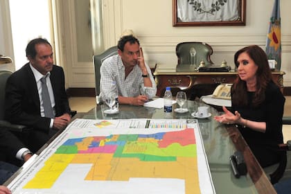 El drama de las inundaciones, en 2013: el entonces gobernador, Daniel Scioli, se reunió con Cristina Kirchner para hablar sobre la tragedia en La Plata; escuchaba Bruera, el intendente
