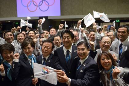 El gobernador de Tokio, el primer ministro de Japón y el CEO de la candidatura, celebran en el momento del anuncio