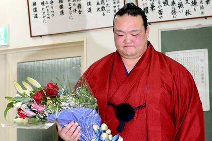 Kisenosato sostiene un ramo de flores después de una conferencia de prensa para anunciar su retiro en el estadio Ryogoku Kokugikan