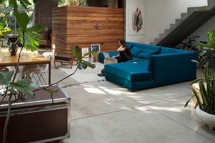 El gran sillón en L sobre el que trabaja Eloisa marca el centro del ambiente.