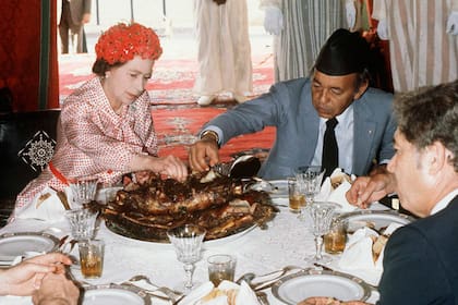 El Grand Carver se encarga de rebanar la carne en el plato de la reina.