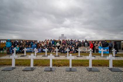 El grupo completo de familiares que viajó al cementerio de Darwin con las banderas