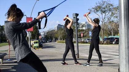 El grupo CRT Training hace ejercicios con pesas y cintas en el vial costero de Vicente López