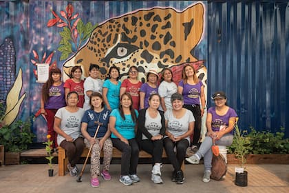 El grupo de mujeres emprendedoras al frente de la Vivera, con el container intervenido como telón de fondo.