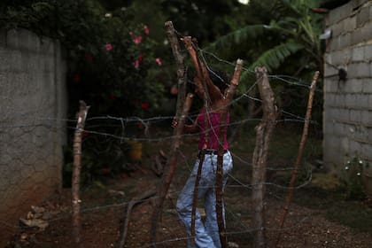 Ignel Yovera mueve una cerca para mostrar dónde los miembros de la FAES mataron a tiros a su hijo Luis Pérez
