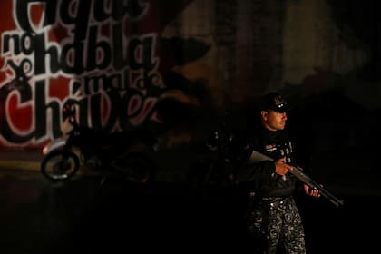 Un miembro de la Fuerza de Acción Especial de la Policía Nacional de Venezuela (FAES) espera en un puesto de control durante una patrulla nocturna, en Barquisimeto