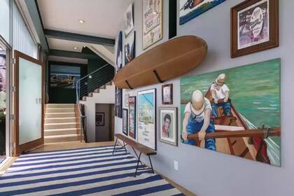 El hall de entrada es una galería en la que la actriz exhibe cuadros, fotos y una antigua tabla de surf.