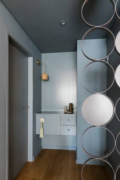 El hall de ingreso no solo impacta: también se equipó con lo elemental para dejar las llaves y todo eso que necesitamos cargar y descargar. Aplique de pared (Mags Design)