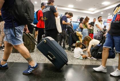 El hall principal del aeroparque porteño desborda de pasajeros que aguardan poder viajar a disfrutar del fin de semana extralargo