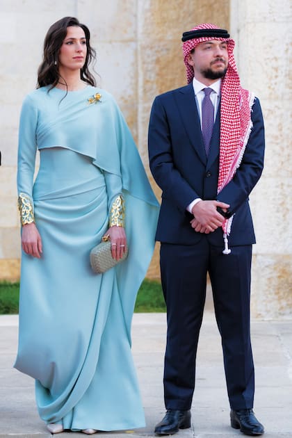 El heredero del trono, el príncipe Hussein, junto a su mujer, la princesa
Rajwa de Jordania. La futura reina llevó un modelo azul cielo de cuello redondo con capa
asimétrica de Reema Dahbour, brazaletes dorados –piezas inspiradas en la caligrafía árabe ornamental– y broche en forma de flor, que combinó con clutch de Bottega Veneta