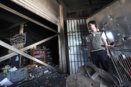 El hijo de Lin Jang Xuan, entre los restos del supermercado que fue incendiado