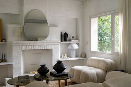 El hogar –que no se usa– también fue pintado de blanco. Espejo ovalado (Ulmen), lámpara blanca (Édition Tupé)