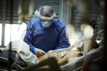 Uno de los enfermeros asiste a un paciente en terapia intensiva