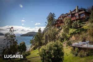 El hotel se ubica sobre un acantilado rocoso frente a Playa Bonita, a orillas del lago Nahuel Huapi