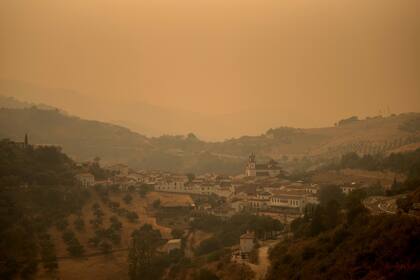 El humo envuelve el pueblo de Atajate debido a un incendio forestal en la Sierra Bermeja en la provincia de Málaga, el 12 de septiembre de 2021