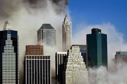 El humo fluye a través de los edificios en Manhattan, visto desde Brooklyn después del colapso del World Trade Center de Nueva York